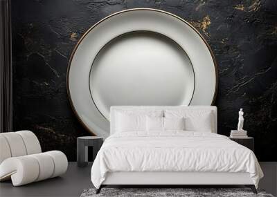 A white plate with a gold rim on a black background Wall mural