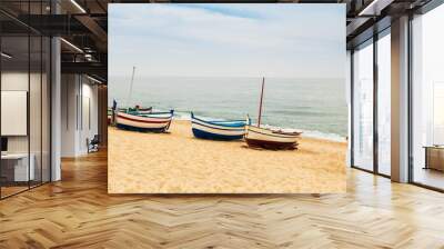 Beautiful multicolored wooden fishing boats on a sandy beach Wall mural