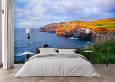 Atlantic ocean coastline of São Miguel Island, Azores, Portugal. Stones, rocks and water at sunset. Nature, landscape photography. Golden hour. Wall mural