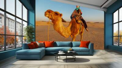 Woman  riding a camel in the Sahara desert. Wall mural