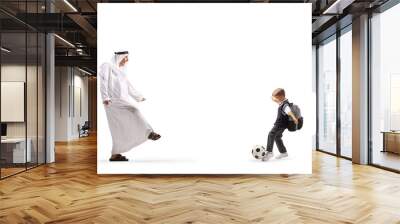 Arab man in traditional robe playing football with a boy Wall mural