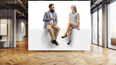 Bearded man talking to a blond woman seated on a panel Wall mural