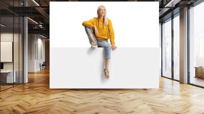 Blond female sitting on a blank panel Wall mural