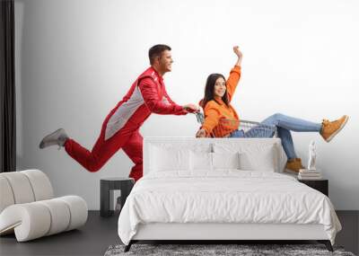 Car racer running and pushing a young woman inside a shopping cart Wall mural