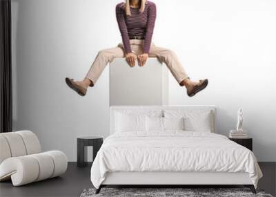 Cheeful young woman sitting on a white column bar Wall mural