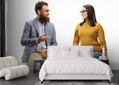 Cheerful bearded man talking to a young female seated on a banner Wall mural