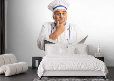 Confused male chef holding a cook book Wall mural