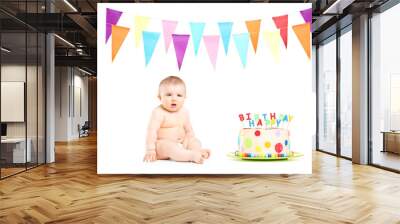 Cute baby boy sitting next to a birthday cake and party flags Wall mural