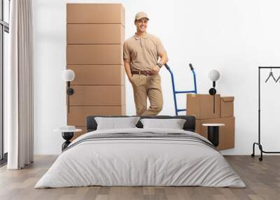 Delivery man with a hand truck leaning on a pile of boxes Wall mural