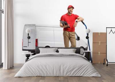 Delivery man with cardboard boxes on hand truck standing in front of a white van Wall mural