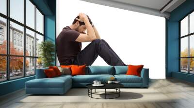 depressed man sitting on the floor with his head down Wall mural