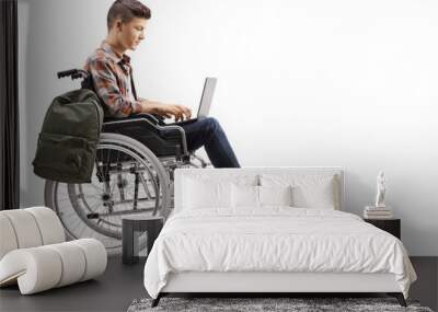 Disabled teenage male student working on a laptop in a wheelchair Wall mural