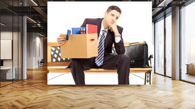 Disappointed redundant young man in a suit sitting on a bench Wall mural