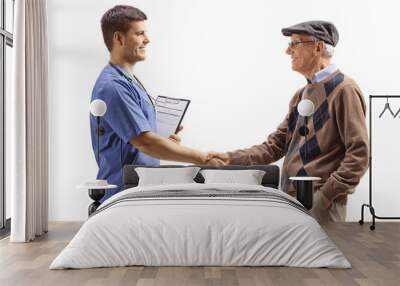 Doctor in a blue uniform shaking hands with a senior man patient Wall mural