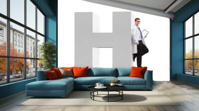 Doctor leaning on a letter H, a sign for hospital Wall mural