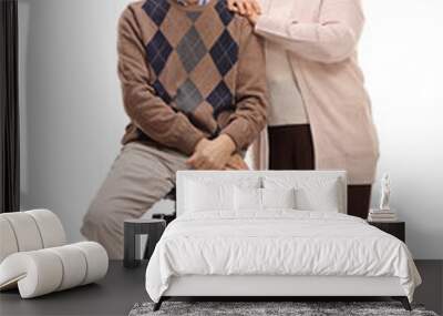 Elderly man sitting on chair with elderly woman standing Wall mural