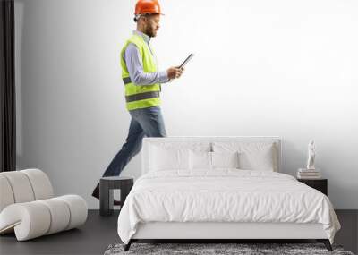 Engineer with a hardhat walking and reading a document Wall mural