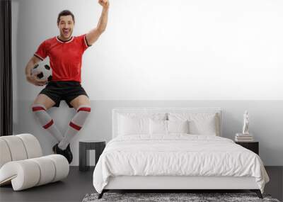 Excited football player sitting on a panel and gesturing happiness Wall mural