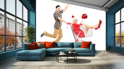 Excited man pushing a cart and woman in christmas costume Wall mural