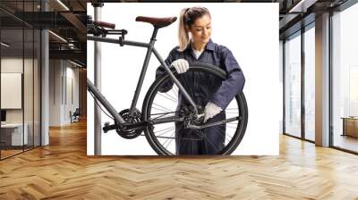 Female bike mechanic repairing a bicycle with a wrench Wall mural