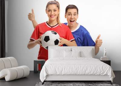 Female soccer player holding football and male soccer player holding his thumbs up Wall mural