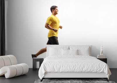 Fit man in a yellow t-shirt and black shorts running Wall mural