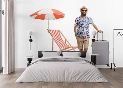 Full length portrait of a bearded man with a suitcase and a beach chair and umbrella Wall mural