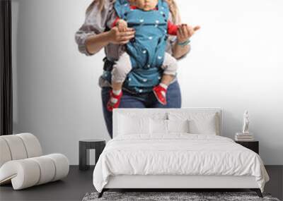 Full length portrait of a mother with a baby in a carrier smiling at camera Wall mural