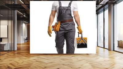 Full length portrait of a repairman in a uniform carrying a tool box and walking towards camera Wall mural