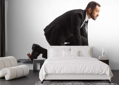 Full length profile shot of a businessman preparing for a run on starting blocks Wall mural