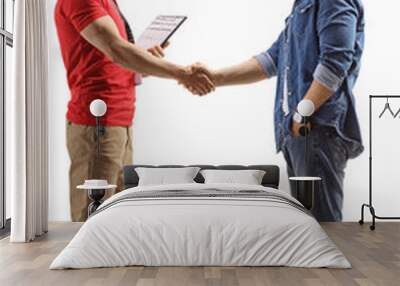 Full length profile shot of a delivery man shaking hands with a man Wall mural