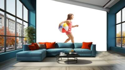 Full length profile shot of a girl running with a beach ball Wall mural