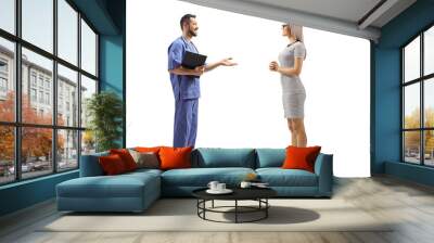 Full length profile shot of a male healthcare workers having a conversation with a young female patient Wall mural