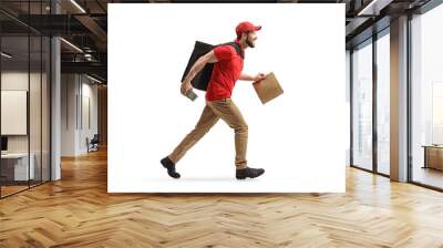 Full length profile shot of a man running with a bag and a payment terminal and delivering food Wall mural