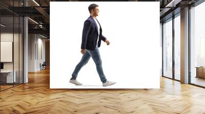 Full length profile shot of a smiling young man in jeans and suit walking Wall mural