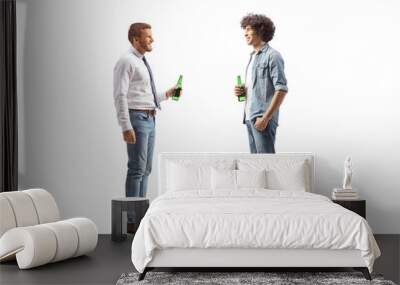 Full length profile shot of a young man with curly hair holding a bottle of beer and talking to a friend Wall mural