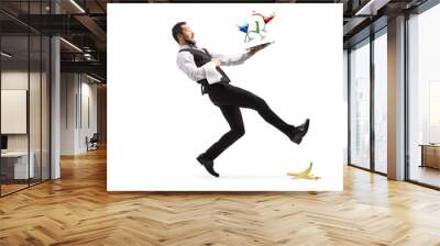 Full length shot of a waiter slipping on a banana peel and falling with a tray of coctails Wall mural