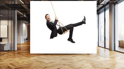 Full length side shot of a happy businessman swinging on a swing Wall mural