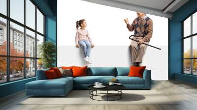 Grandfather sitting on a blank panel and talking to a little girl Wall mural