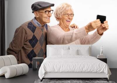 Happy senior man and woman taking a photograph with a mobile phone Wall mural