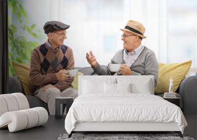 Joyful seniors on a sofa talking Wall mural