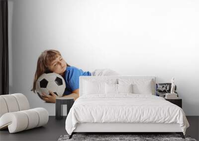 Little girl in a football kit sleeping with a ball Wall mural