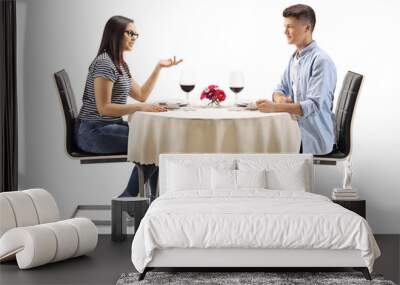 Male and female teenagers sitting at a restaurant table and talking Wall mural