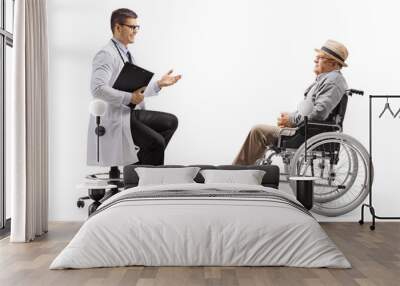 Male doctor talking to a mature male patient in a wheelchair Wall mural