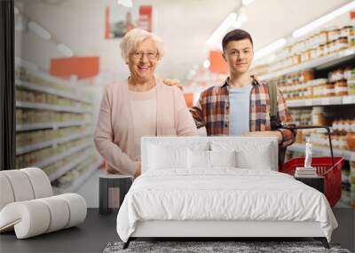 Male student helping an elderly woman with shopping Wall mural