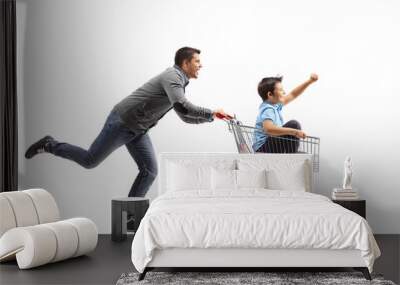 Man running and pushing a boy inside a shopping cart Wall mural