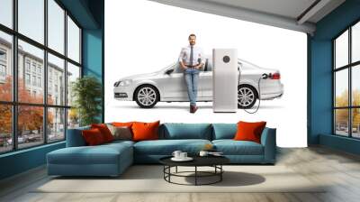 Man with a silver car at EV charging point Wall mural