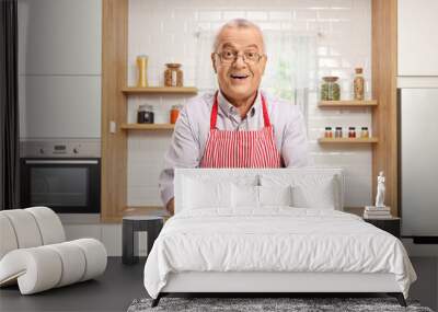 Mature man holding a freshly baked pie and standing in a kitchen Wall mural