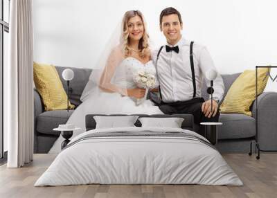 Newlywed couple posing together on a sofa Wall mural