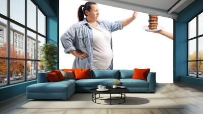 Overweight woman refusing to eat donuts Wall mural